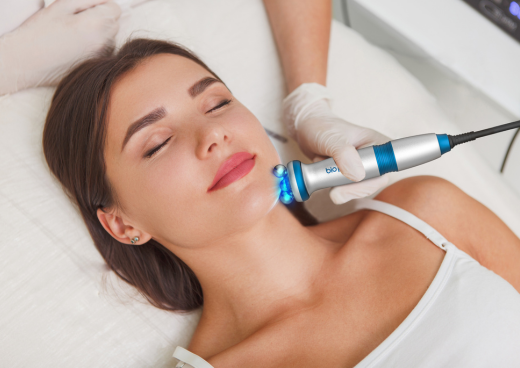Woman enjoying her skin treatment with (RF) radiofrequency skin tightening device