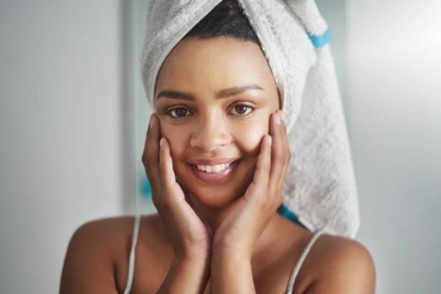  Woman with hair wrapped in a towel, touching her hands to her face