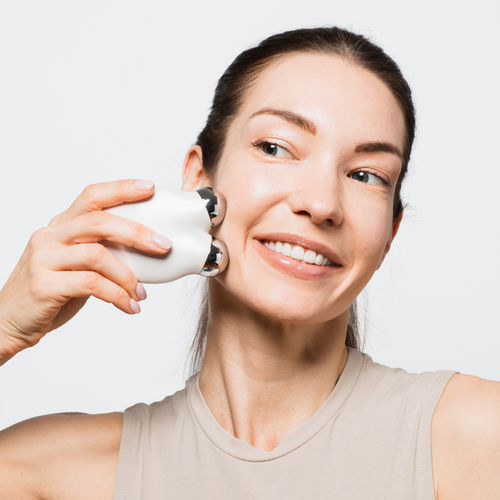 a woman using Femvy Microcurrent Facial Toning Device