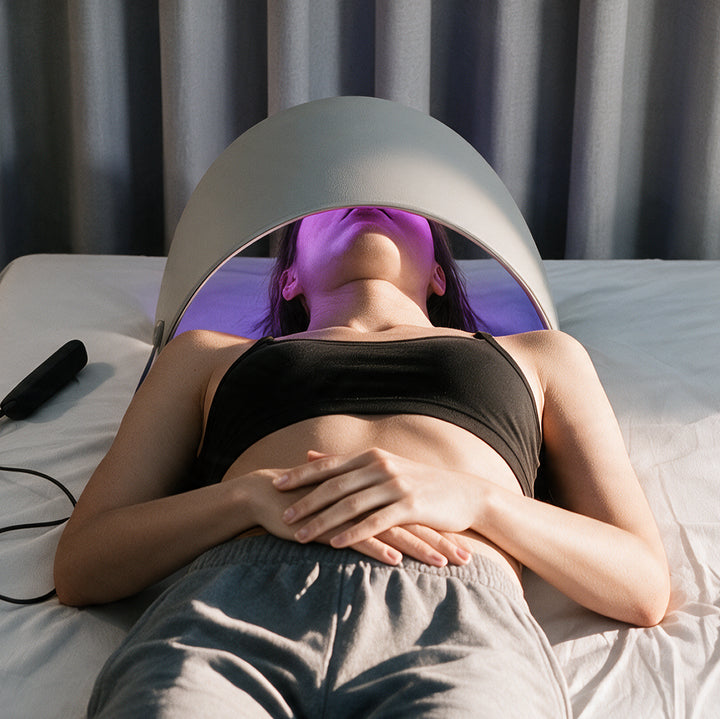 Woman relaxing under the GOOMi 3D Silicone LED Light Therapy Mask during an at-home light therapy session