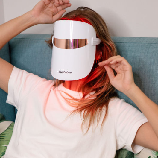 A women wearing Peachaboo Glo LED Light Therapy Mask for skin treatment at home