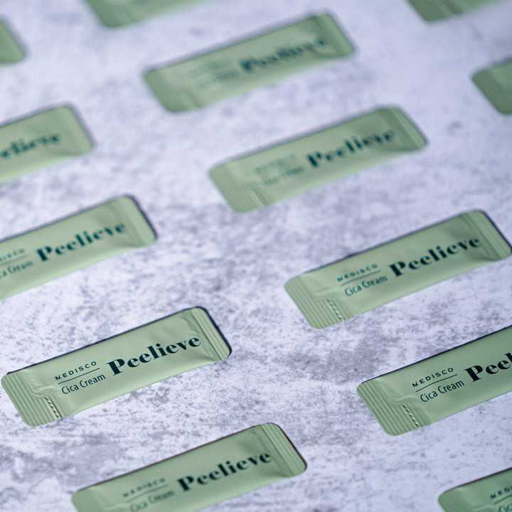 Multiple green sachets of Medisco Peelieve Cica Cream on a textured surface