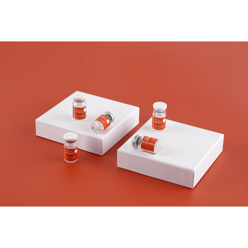 Medisco MesO PDRN Ampoule vials showcased on white blocks against an orange backdrop.