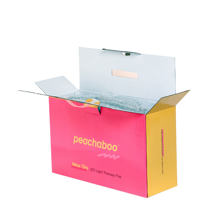 Pink box labeled "Peachaboo LED Light Therapy Pod" with vibrant yellow and pink writing on the surface.