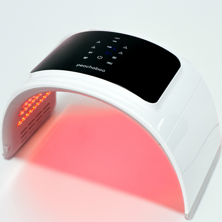 Close-up of Peachaboo’s red LED light therapy pod in use, emitting a warm red glow for skin rejuvenation.