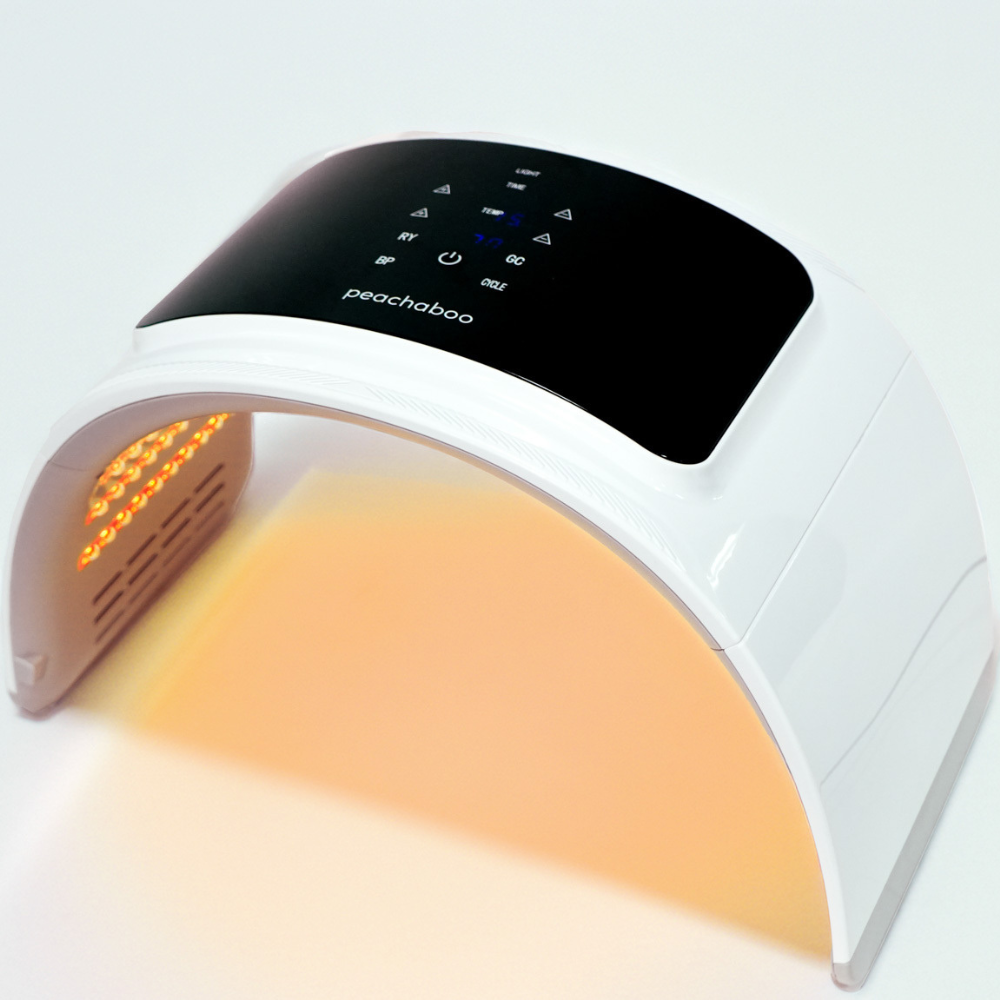 Close-up of Peachaboo’s yellow LED light therapy pod in use, emitting a gentle yellow glow to calm redness and soothe sensitive skin.