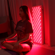 Load image into Gallery viewer, PeakMe Red Light Therapy Panel RD1500 (Best for Full Body Treatment) young female sitting infront of the panel