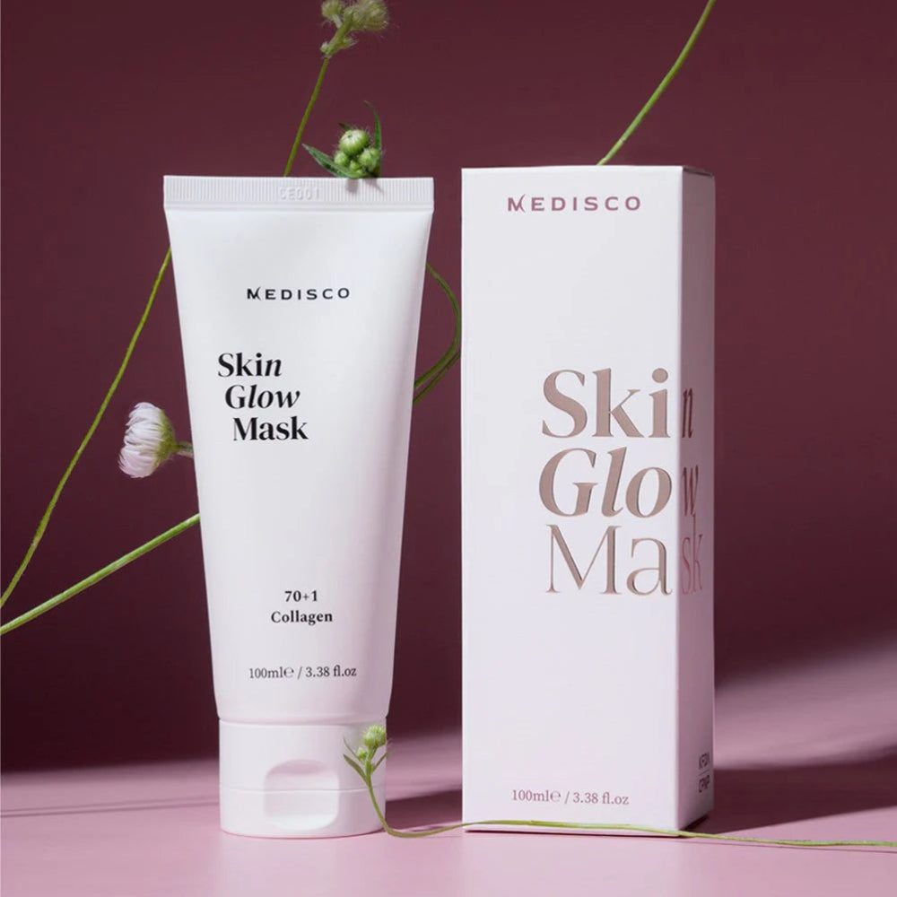 Close-up of Medisco SkinGlow PDRN Collagen Mask tube and box styled with floral accents.