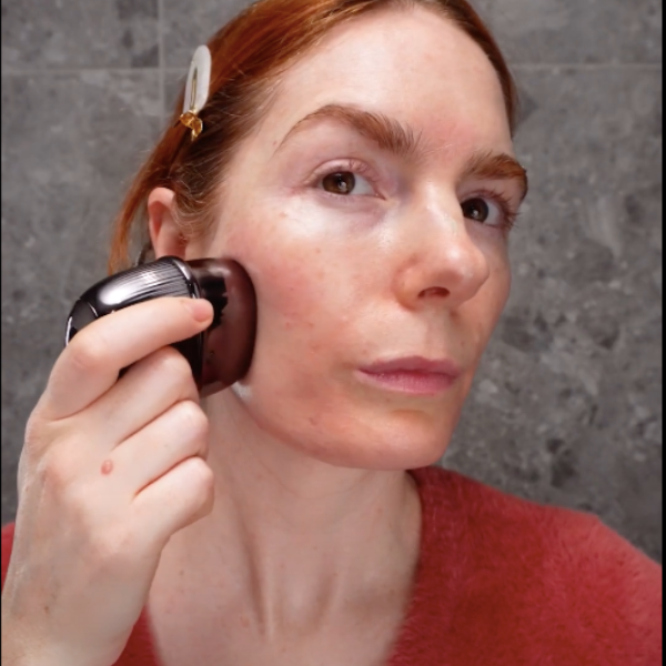 A woman applies a brush to her face, demonstrating the RF Matrix Max Skin Tightening Device in grey.