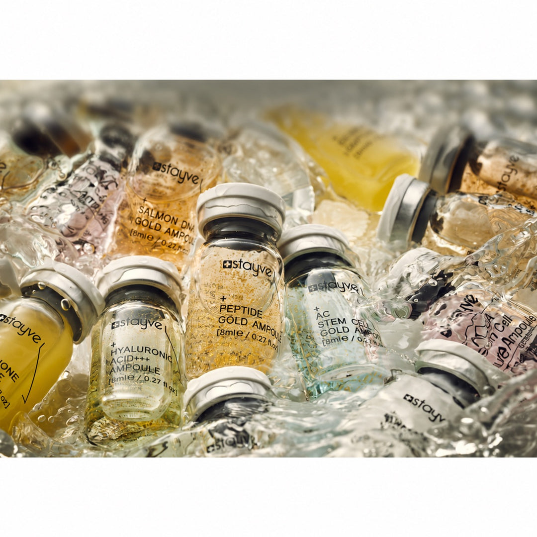 Several Stayve skincare ampoules including Peptide Gold, Hyaluronic Acid and Stem Cell formulas immersing in water. 